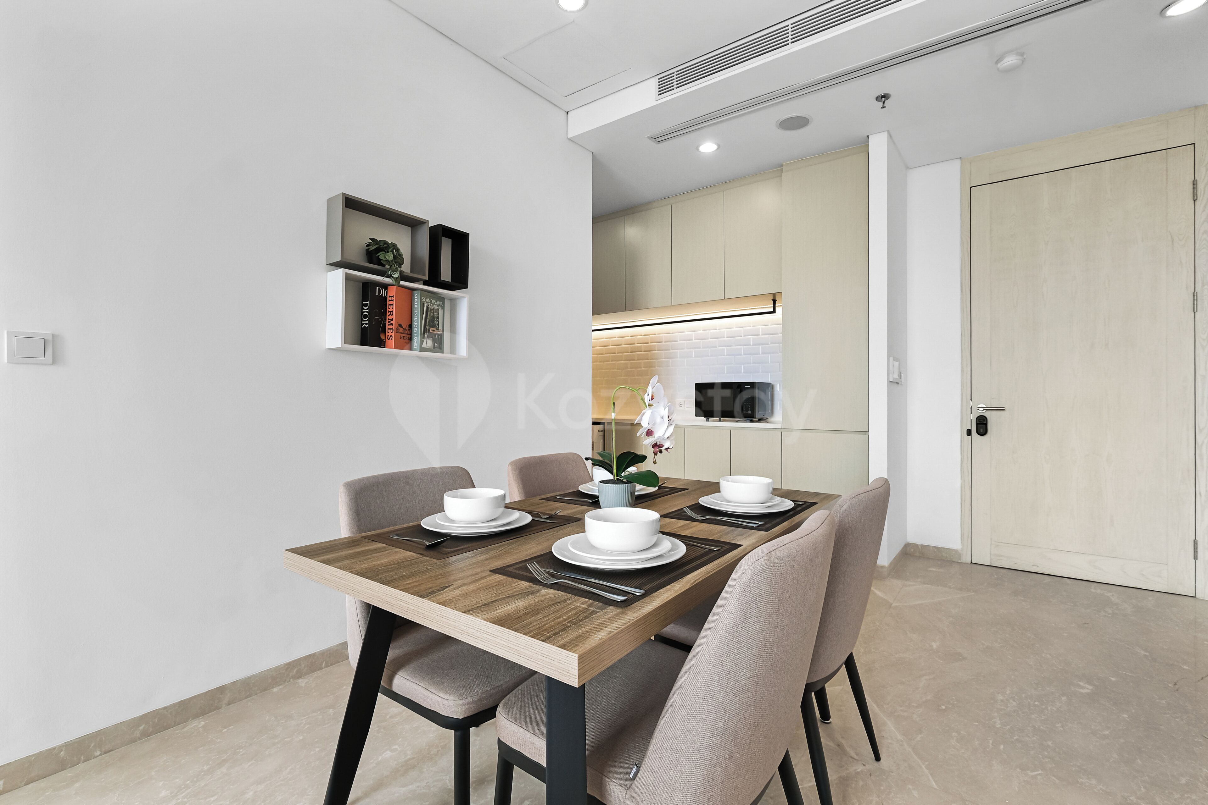 A modern dining area with a wooden table set for four, surrounded by chairs.
