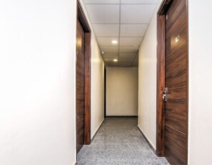 Un pasillo con puertas de madera y techo de baldosas.
