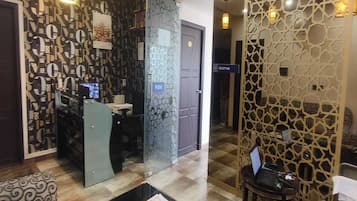 A reception area with a modern design, including a patterned wall, a reception desk, and a seating area with patterned cushions.