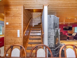 Un interior de fusta amb una escala que porta a una llar de pedra.