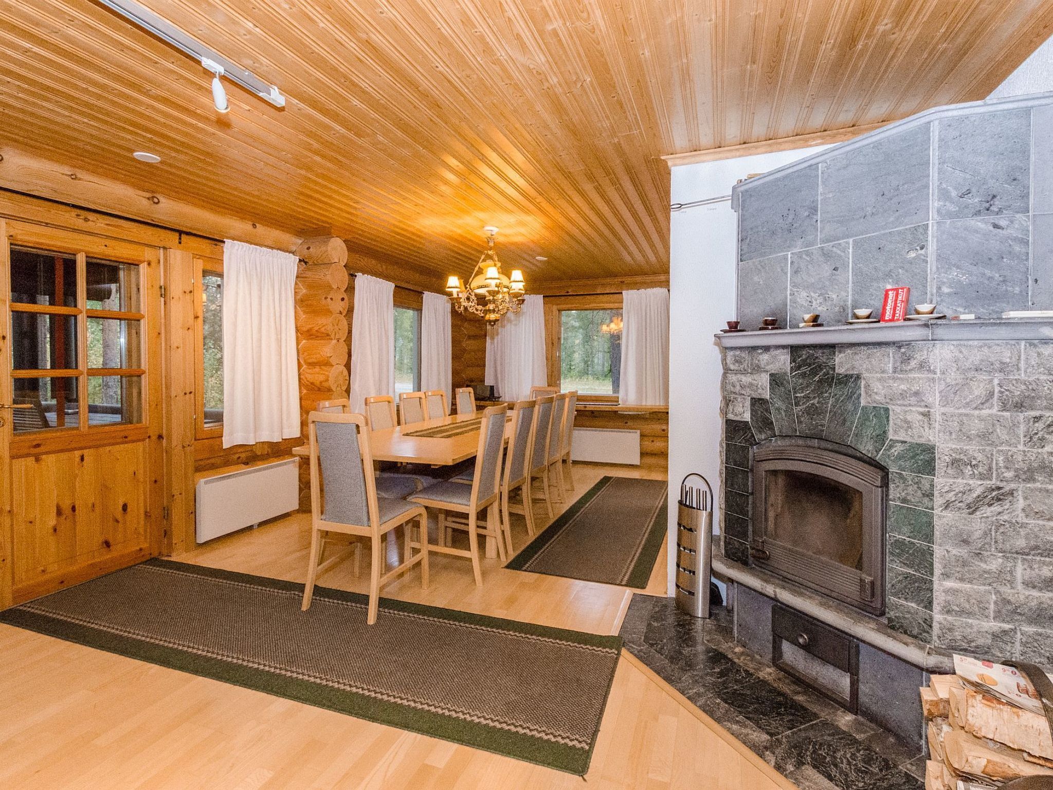 Ein Holzblockhaus-Interieur mit Essbereich, Kamin und Holzwänden.