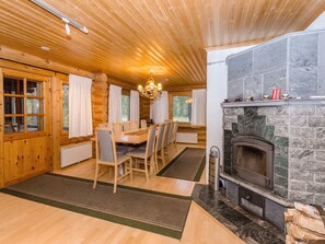 Ein Holzblockhaus-Interieur mit Essbereich, Kamin und Holzwänden.