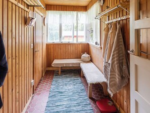 A wooden interior with a bench, a window with curtains, and a towel rack. - Vacation home Alpola by Interhome (Suomussalmi)