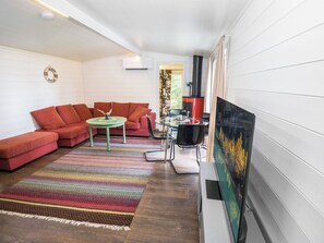 Una sala de estar con un sofá rojo, una mesita redonda y una alfombra colorida.