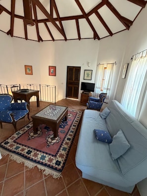 A living room with a sofa, chairs, a coffee table, and a television. - Sato Triopia Apart Otel (Muğla)
