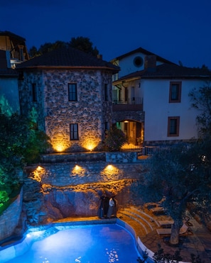 A stone building with a swimming pool, surrounded by trees and a stone wall. - Sato Triopia Apart Otel (Muğla)