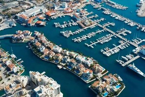 An aerial view of a marina with numerous boats docked, surrounded by residential buildings with balconies and swimming pools. - Spacious Entire Floor Penthouse 200m To The Beach (Limassol)
