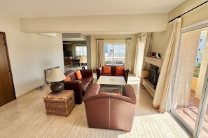 A modern living room with a sofa set, a coffee table, and a TV. There is a wicker basket and a lamp on the floor. - Spacious Entire Floor Penthouse 200m To The Beach (Limassol)