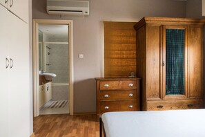 A bedroom with a wooden wardrobe, a bedside table, and a bed. - Spacious Entire Floor Penthouse 200m To The Beach (Limassol)