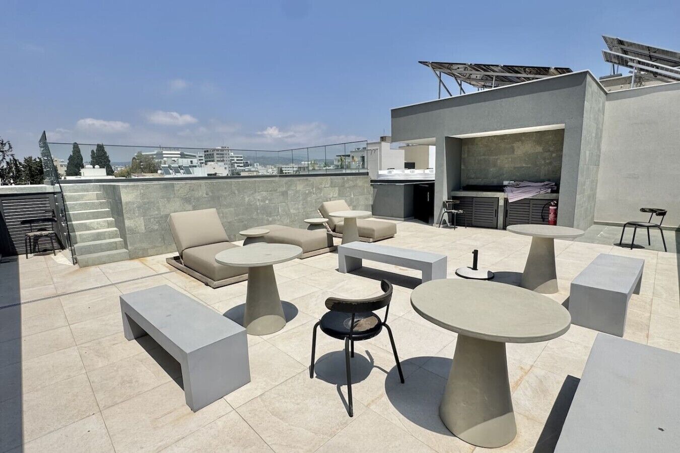 A rooftop terrace with outdoor seating, a barbecue area, and solar panels.