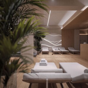A modern spa room with wooden flooring, white lounge chairs, and a wall with a light wave design. - Kazzhol Seven Almaty  (Almaty)