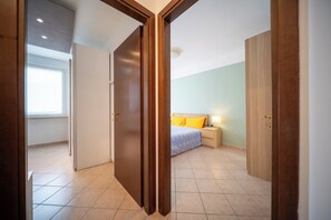 Un dormitori amb llit, taula de nit i armari.