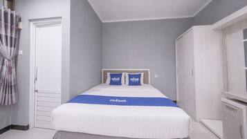 A bedroom with a bed, a wardrobe, and a curtain.
