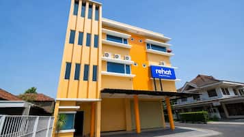 A modern hotel with a yellow facade, multiple floors, and a sign indicating it is a sleep well sleep hotel.