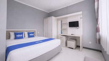 A hotel room with a bed, a desk, a television, and a wardrobe.