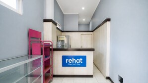 A kitchenette area with a sign for 'Rehat Sleep Well Sleep' and a water dispenser. - Rehat at The Karins Guest House (Bandung)
