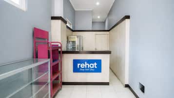 A kitchenette area with a sign for 'Rehat Sleep Well Sleep' and a water dispenser.