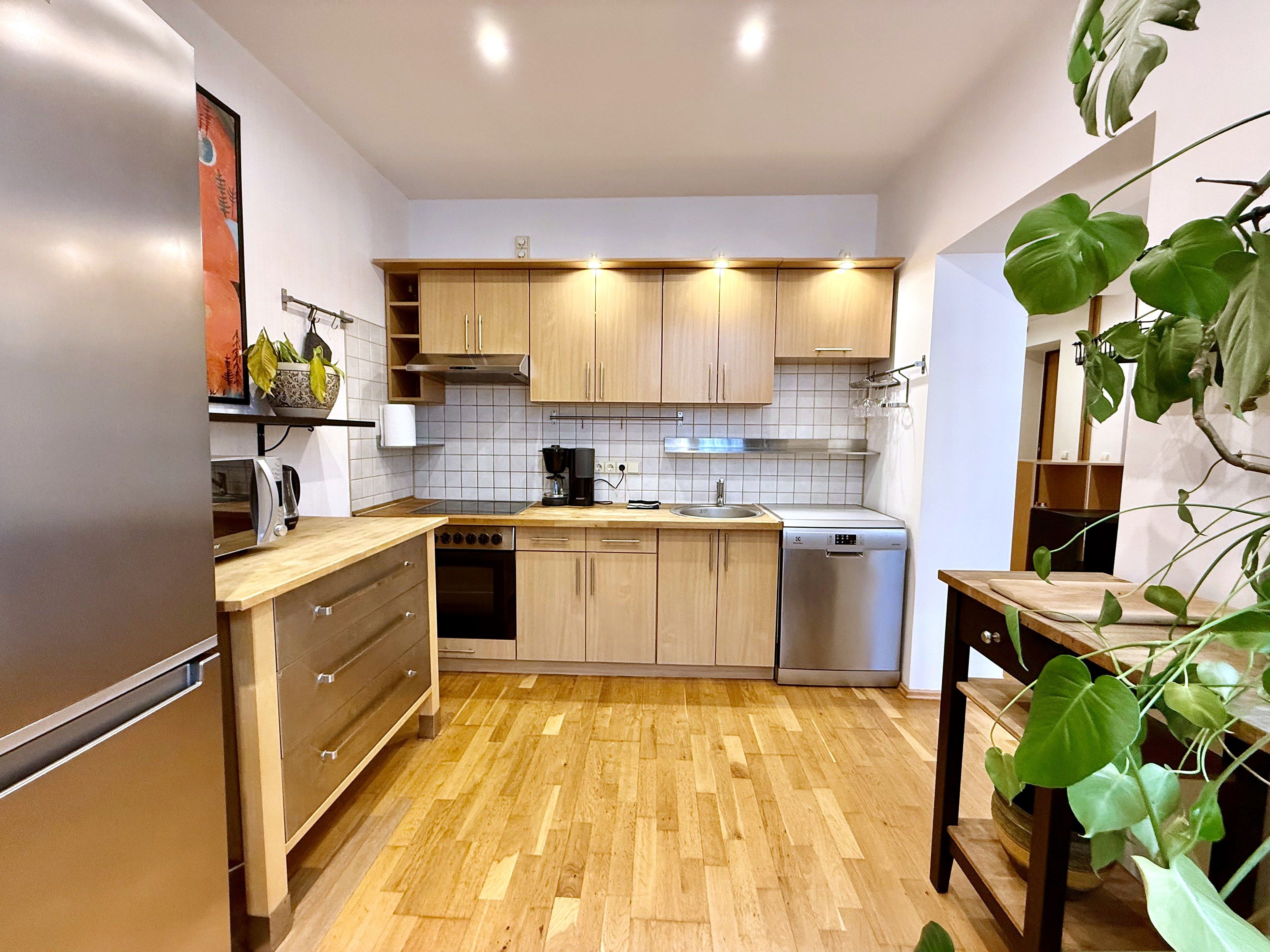 Eine moderne Küche mit Holzschränken, einem Backofen und einem Geschirrspüler.