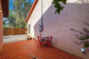 A patio with a brick floor, a table, and two chairs. - Couple’s Casita Near Historic Downtown Roswell! (Roswell)