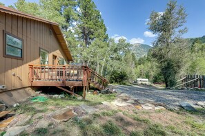 Une cabane en bois avec une terrasse et une allée gravillonnée.