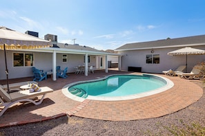 A backyard with a swimming pool, patio furniture, and a covered seating area. - Heated Pool, Spa & Game Room: Yucca Valley Retreat (Yucca Valley)