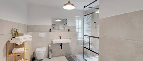 A modern bathroom with a toilet, sink, and shower area.