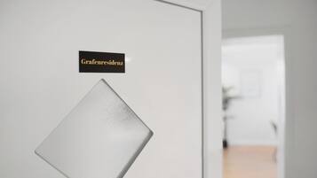 Una porta con un pannello di vetro smerigliato e un cartello con la scritta 'Grafenresidenz'.