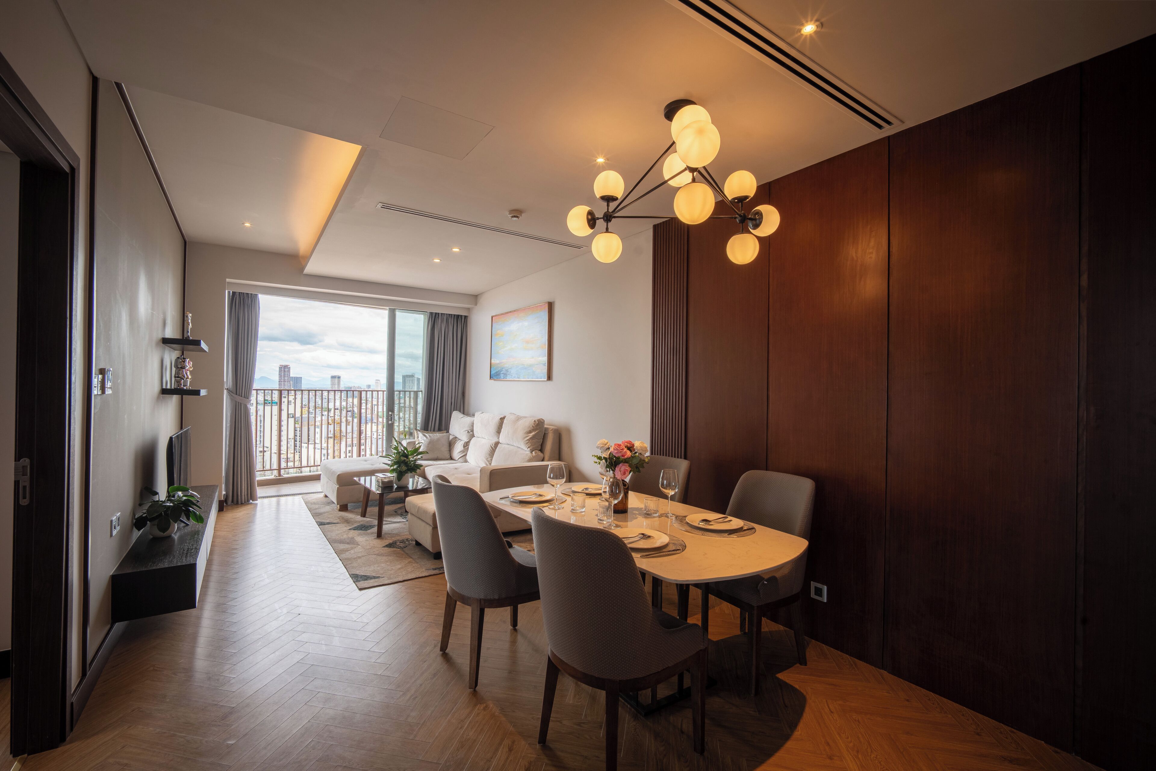 Un salon moderne avec un coin repas, de grandes fenêtres et une vue sur le paysage urbain.