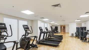 Ein Fitnessstudio mit Laufbändern, Crosstrainern und Gewichten.