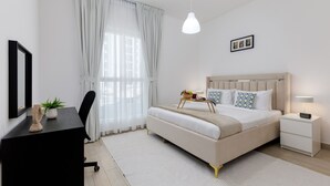 Een moderne slaapkamer met een bed, nachtkastjes, een bureau en een stoel.