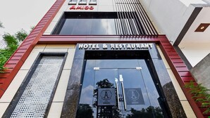 A hotel entrance with a sign reading 'AMIGO HOTEL & RESTAURANT' and a logo with a stylized 'A'. - Deluxe Hotel Amigo (Thanesar)