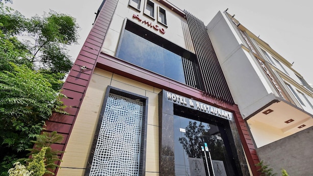 A hotel with a modern facade, large windows, and a sign indicating it is a hotel and restaurant. - Deluxe Hotel Amigo (Thanesar)