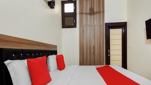 Una habitación de hotel con cama, armario y televisor.