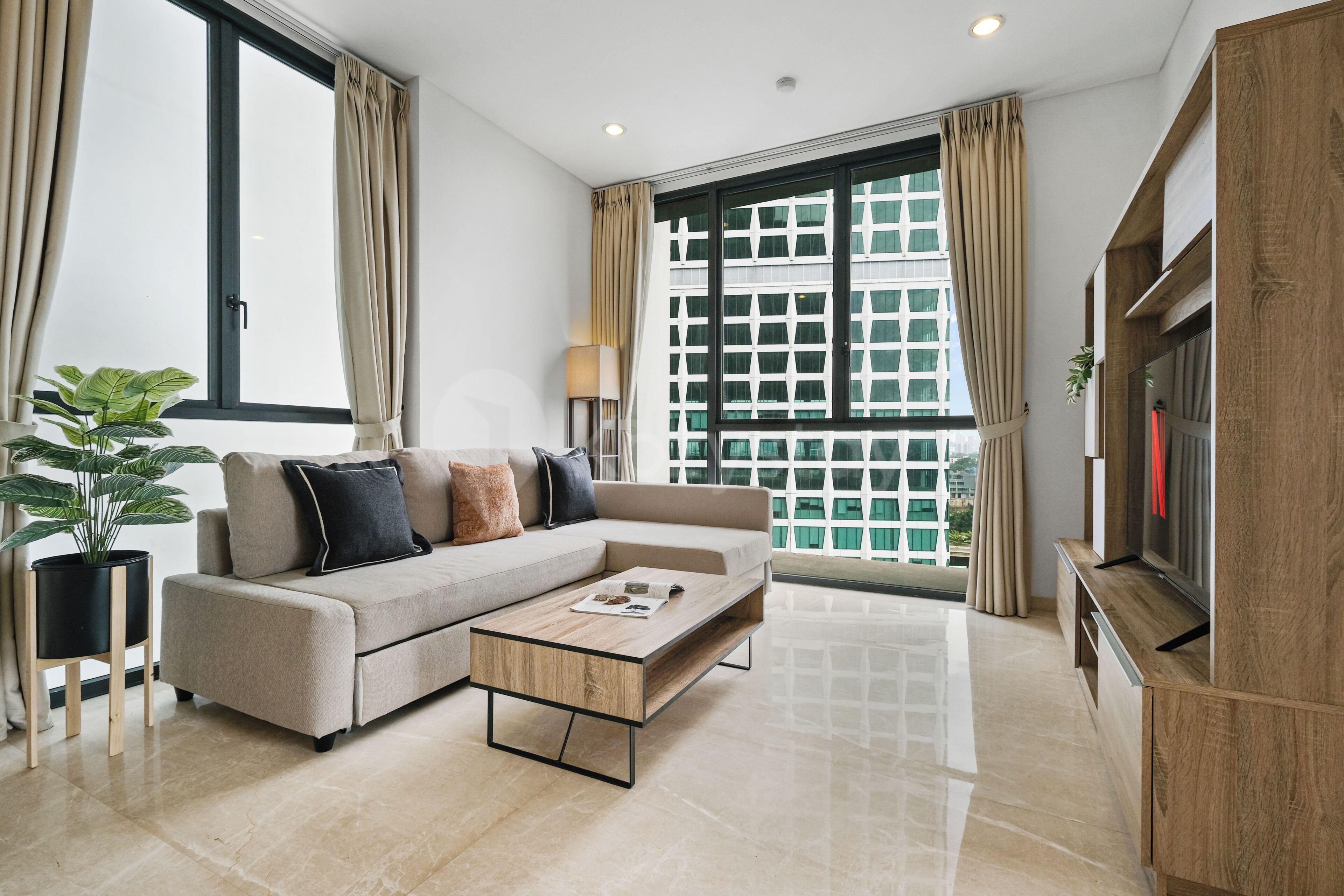 A modern living room with a sofa, coffee table, and a TV on a wooden cabinet.
