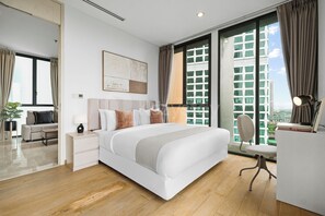 Une chambre d’hôtel moderne dotée d’un grand lit, d’un bureau, d’une chaise et offrant une vue sur la ville grâce à de grandes fenêtres.