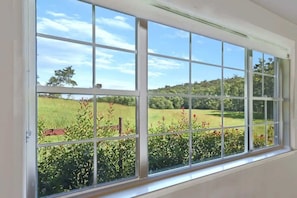 A window with a view of a grassy field and trees. - Laguna Homestead - Scenic Country Escape (Cessnock City Council)