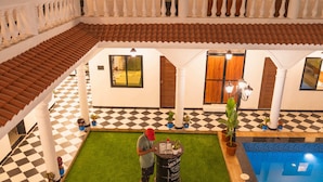 A poolside area with a checkered floor, a bar area with a Jack Daniel's barrel, and a pool with a tiled edge.