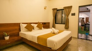 A hotel room with a wooden bed, a potted plant, and a window with curtains.
