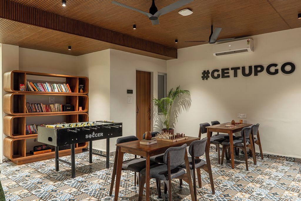 A room with a foosball table, a bookshelf, a chess table, and a wall with a hashtag sign.