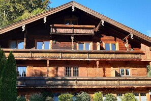 Un edificio de madera de varios pisos con balcones y ventanas grandes.