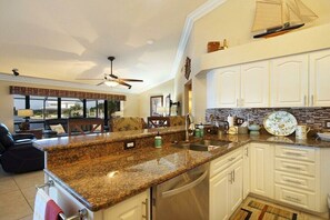 A kitchen with granite countertops, stainless steel appliances, and white cabinetry. - Villa in Cape Coral with swimming pool (Cape Coral)