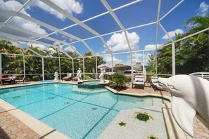 Une piscine à l’eau d’un bleu cristallin, entourée d’une structure en forme de tonnelle blanche.