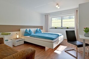 Ein modernes Schlafzimmer mit Bett, Nachttischen, Schreibtisch und Stuhl.