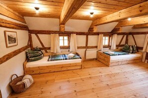 A room with two wooden beds, a window, and a radiator. - Gebirgshäusl Oybin / Zittau Mountains (Oybin)