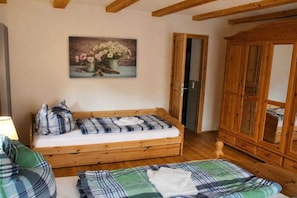 Una habitación acogedora con una cama y un armario de madera, y un cuadro en la pared.