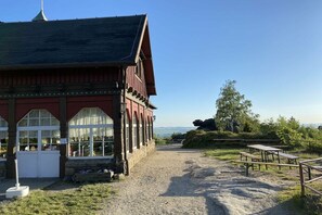 A building with a red facade and a gravel path leading to picnic tables. - Gebirgshäusl Oybin / Zittau Mountains (Oybin)