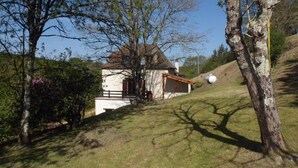 A house with a sloped roof, a small attached structure, and a grassy yard.