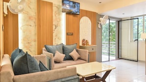 Una sala de estar moderna con un sofá, una mesa de centro, un televisor montado en la pared y un elemento decorativo en la pared.