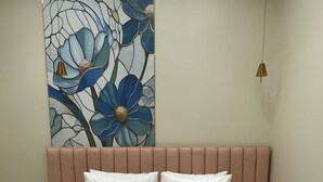 A bedroom with a large bed, a headboard, two bedside tables, and a wall-mounted light fixture. - Aliste Hotel Prem Mandir Vrindavan (Vrindavan)