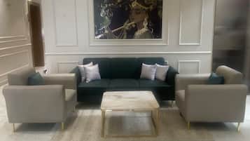 Un hall con un conjunto de sofás, una mesa de centro y un cuadro grande en la pared.